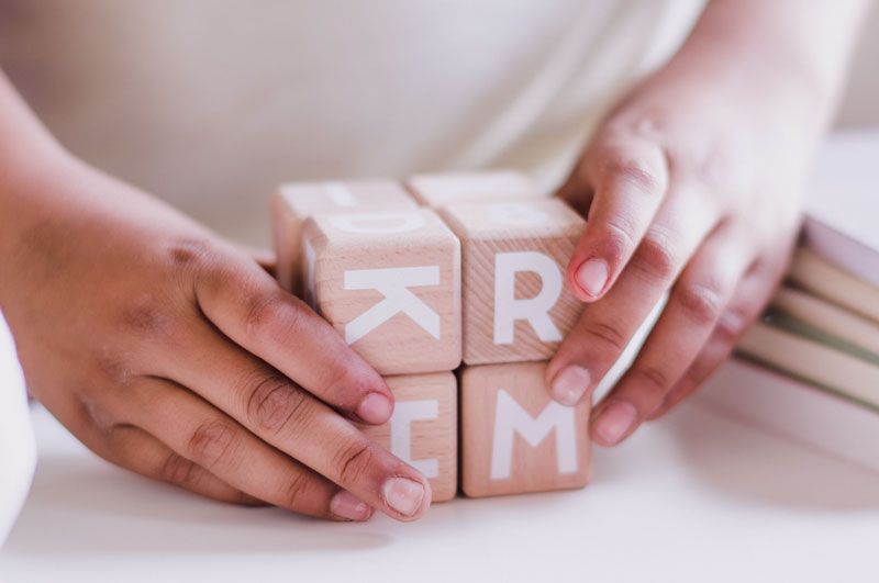close up of kid's hands on wooden alphabet blocks at Lakeland Baptist Church in Iron River, Michigan