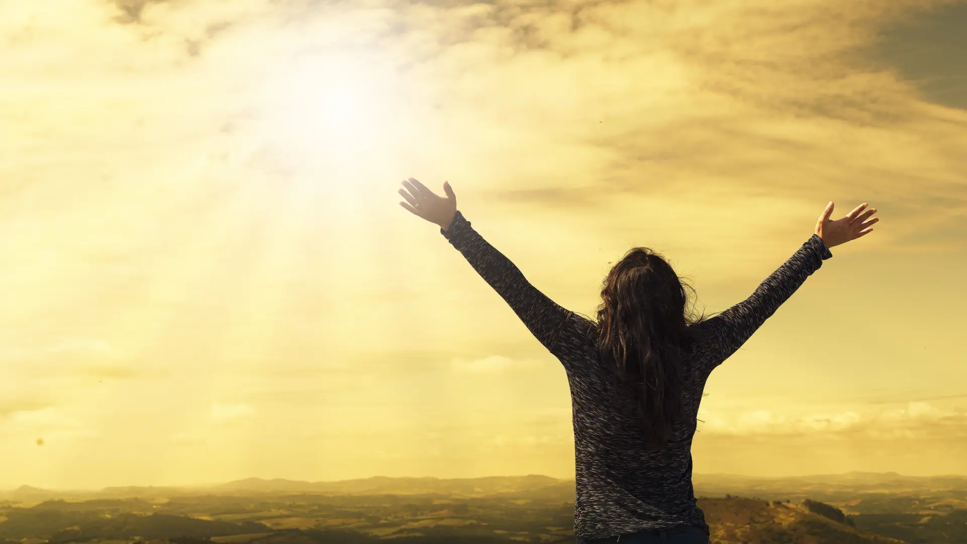 woman lifting up her hands in worship at Lakeland Baptist Church in Iron River, Michigan